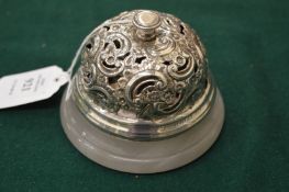 An early 20th century table bell with pierced and embossed white metal mounts on an onyx base.