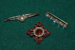 Three decorative brooches.