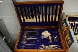 An oak cased part canteen of cutlery.
