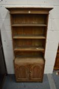 A limed oak small cupboard bookcase.