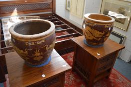 A large pair of Chinese glazed earthenware jardinieres decorated with dragons chasing the pearl of
