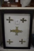 A group of bronze crosses, framed and glazed.
