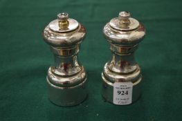 A pair of silver salt and pepper grinders.