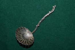 A silver shell shaped tea caddy spoon.