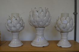 A set of three artichoke style candle holders.