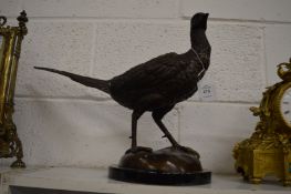 A cast bronze model of a cock pheasant mounted on a circular marble base.