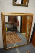 A large modern gilt framed mirror.