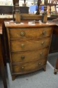 A reproduction small bow front chest of drawers.