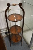 A mahogany three-tier folding cake stand.