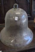 A pair of large glass bell shaped cloches, one with rim chips.