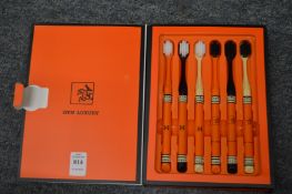 A boxed set of six stylish toothbrushes.