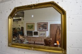 A gilt framed over mantel mirror with shaped top.