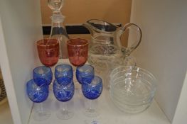 A set of six blue glass goblets and other glassware.