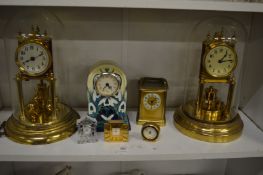 Two brass anniversary mantel clocks and other clocks.