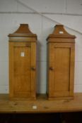 A pair of small oak cupboards.
