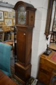 A small reproduction oak long case clock with arch dial, the movement striking on a gong.