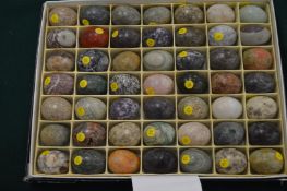 A boxed set of 49 small egg shaped specimen stones.
