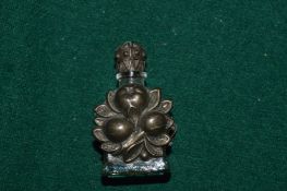 A miniature white metal mounted glass scent bottle.