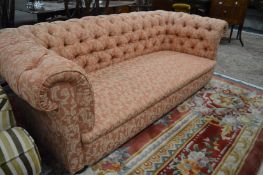 A Chesterfield settee upholstered with a classical style material.