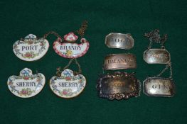 A collection of silver, silver plate, porcelain and enamel decanter labels.