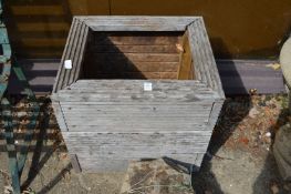 A wooden square shaped planter.