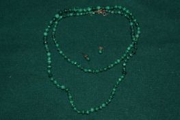A malachite bead necklace and a pair of matching ear studs.