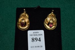 A pair of decorative yellow metal and gem set earrings.