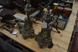A pair of ornate cast brass fire dogs.