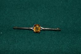 Yellow metal bar brooch inset with a citrine.