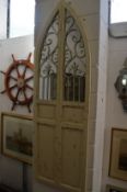 A decorative arch shaped window style mirror with painted frame.