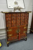 A good Chinese miniature multi-drawer chest with pair of cabinet doors and decorative brass mounts.