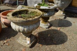 Two weathered composite garden urn shaped planters.