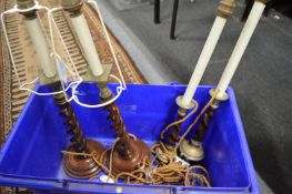 Two pairs of wooden barley twist candlesticks.