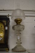 A glass oil lamp with etched glass shade.