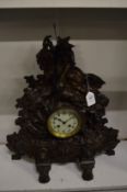 A decorative cast metal mantel clock.