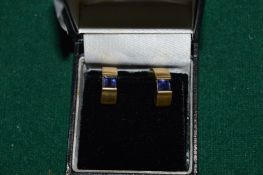 A pair of 14ct gold and sapphire earrings of a stylish Art Deco design.