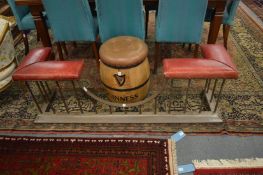 A steel club fender with burgundy leather upholstered seat.