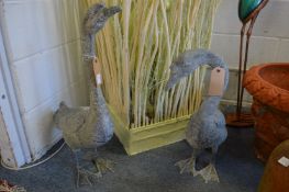 A pair of patinated metal model of geese.