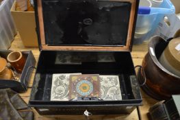 A black japanned tin box and three old tiles.