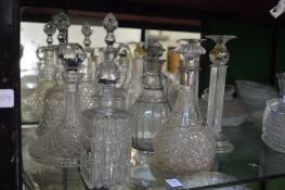 A collection of decanters and a pair of glass candlesticks.