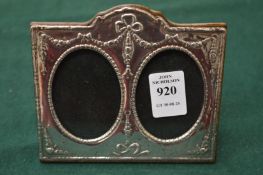 An embossed silver double photograph frame.