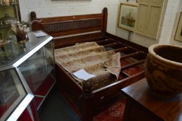 A large Indonesian hardwood bed frame with carved and pierced decoration, 6ft 6in x 6ft.