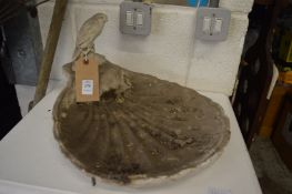 A shell shaped bird bath.