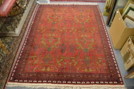 Persian design rug, red ground with stylised gold coloured decoration, 208cm x 152cm.