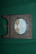Miniature portrait of the Taj Mahal in a carved wood frame.