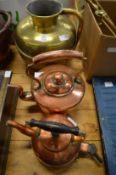 An Eastern brass ewer and two copper kettles.