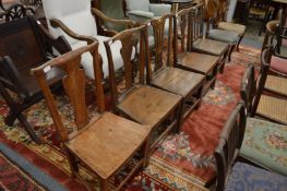 A group of country made elm dining chairs with solid seats.