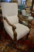 A large upholstered open armchair with carved frame.