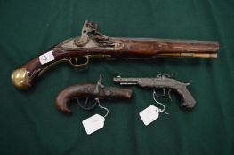 A 19th century flintlock holster pistol and two reproduction pistols.