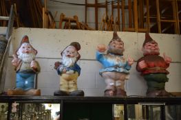 Four large painted resin models of gnomes.